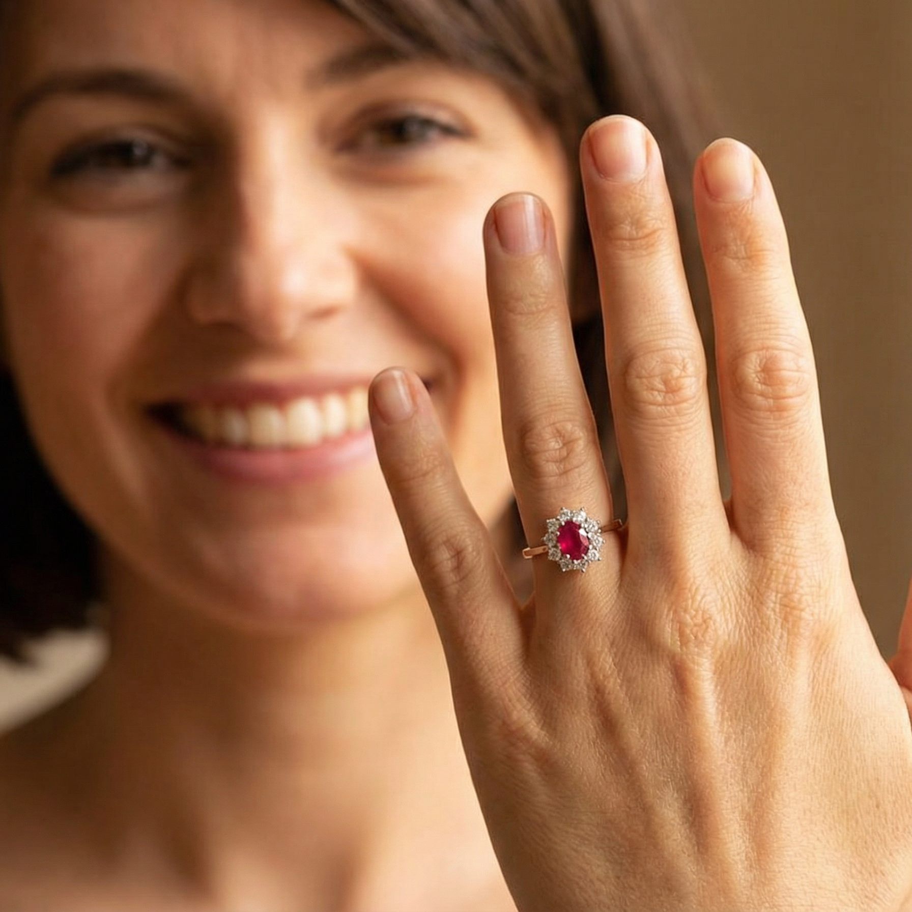 model A classic cluster ring centred with an oval pinkish-red ruby measuring approximately 9 × 6 mm (estimated 1.75 carats)