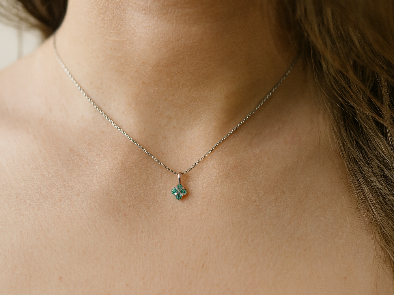 model A delicate pendant crafted in 18ct white gold, featuring a cluster of four round emeralds,