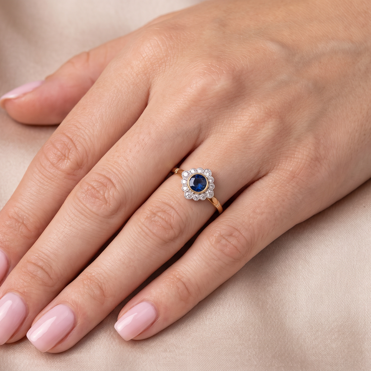 model A fine cluster ring featuring to the centre a round dark blue sapphire, 5mm diameter (0.50 carats) mille grain setting.