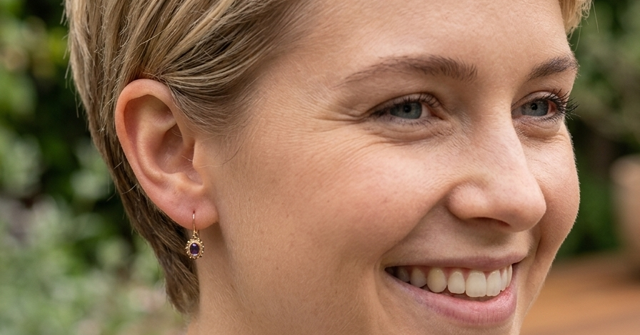 model A pair of drop earrings. Each set with a cabouchon cut amethyst 6x4mm and set with an antique look border.