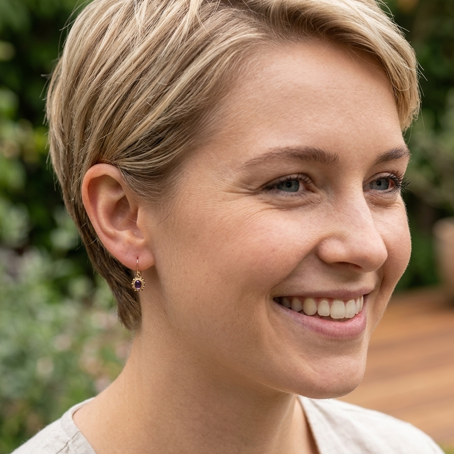 model A pair of drop earrings. Each set with a cabouchon cut amethyst 6x4mm and set with an antique look border.