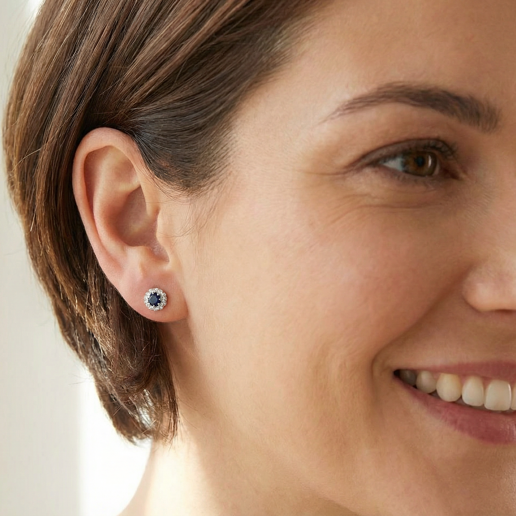model A pair of stud cluster earrings. Each earring is set with a dark blue sapphire centre .
Measures 4mm, surrounded by an outer halo of eight 1.3mm diamonds