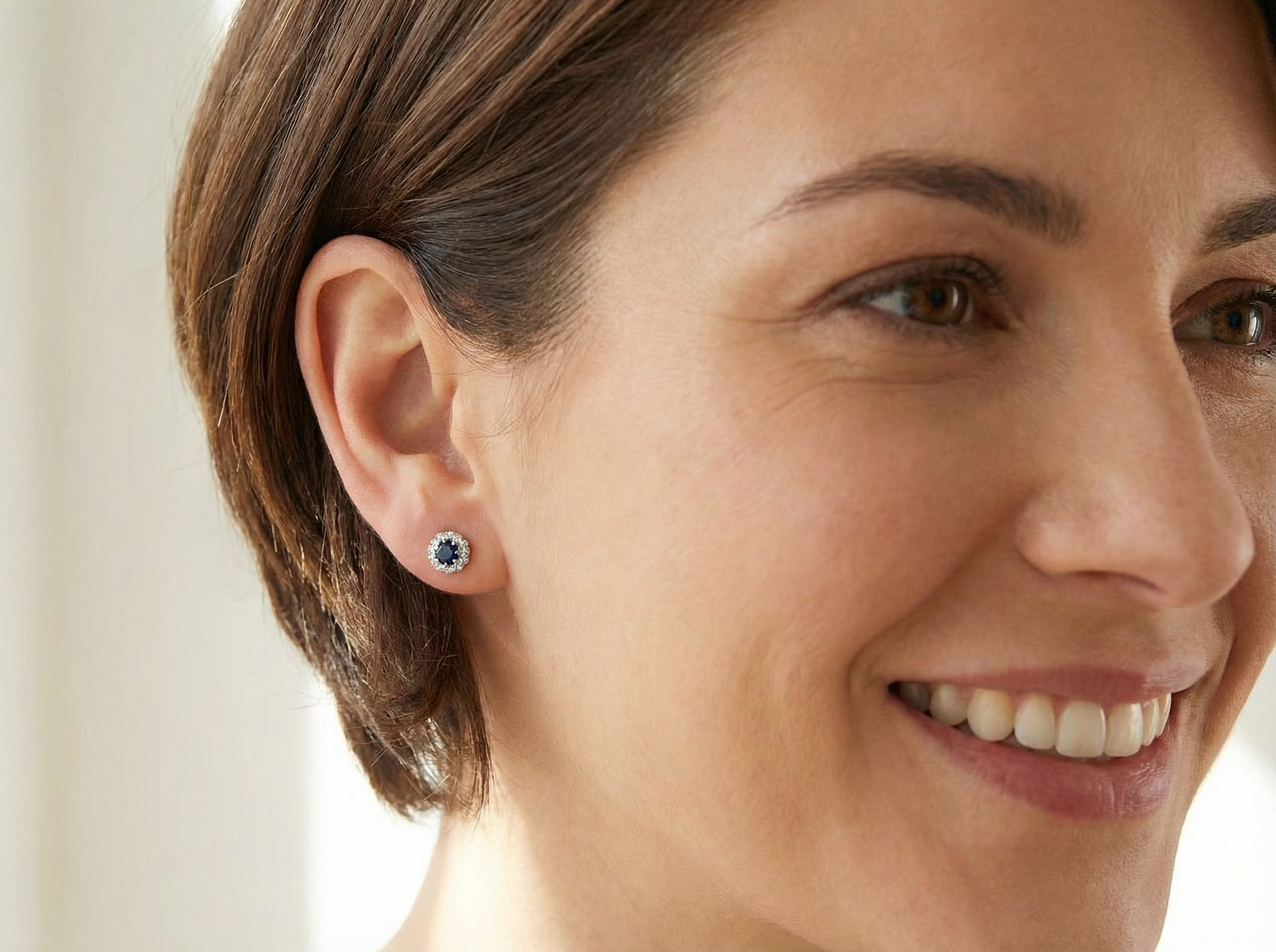model A pair of stud cluster earrings. Each earring is set with a dark blue sapphire centre .
Measures 4mm, surrounded by an outer halo of eight 1.3mm diamonds