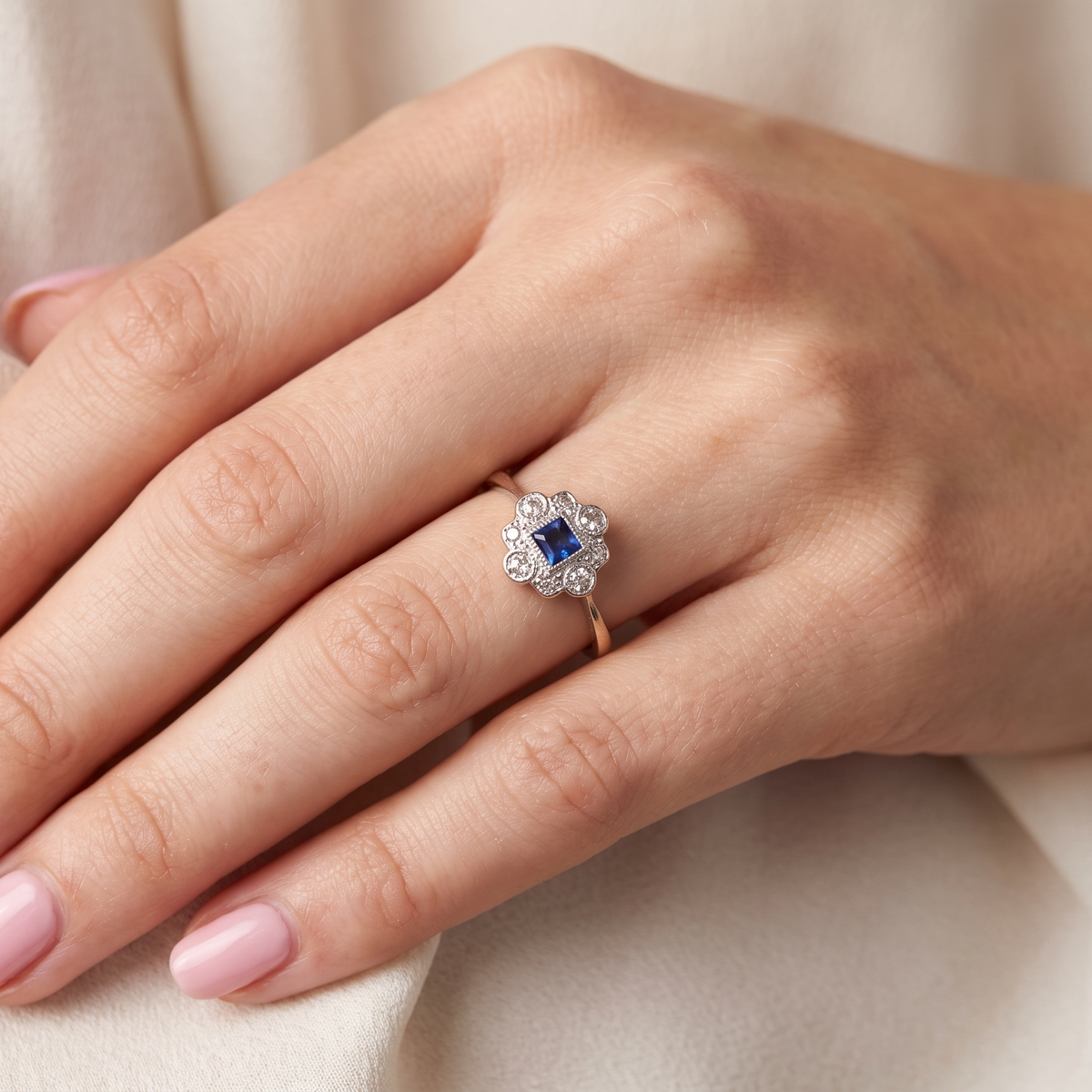model A pretty early 20th century cluster ring. The centre stone a square mid blue sapphire, 3x3mm, mille grain setting. 