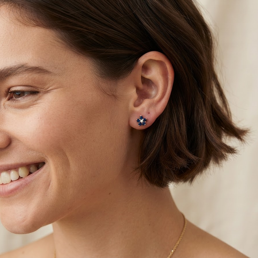 model A pretty pair of gold earrings each floral shaped with a small diamond centre stone surrounded by five petals, these round sapphires