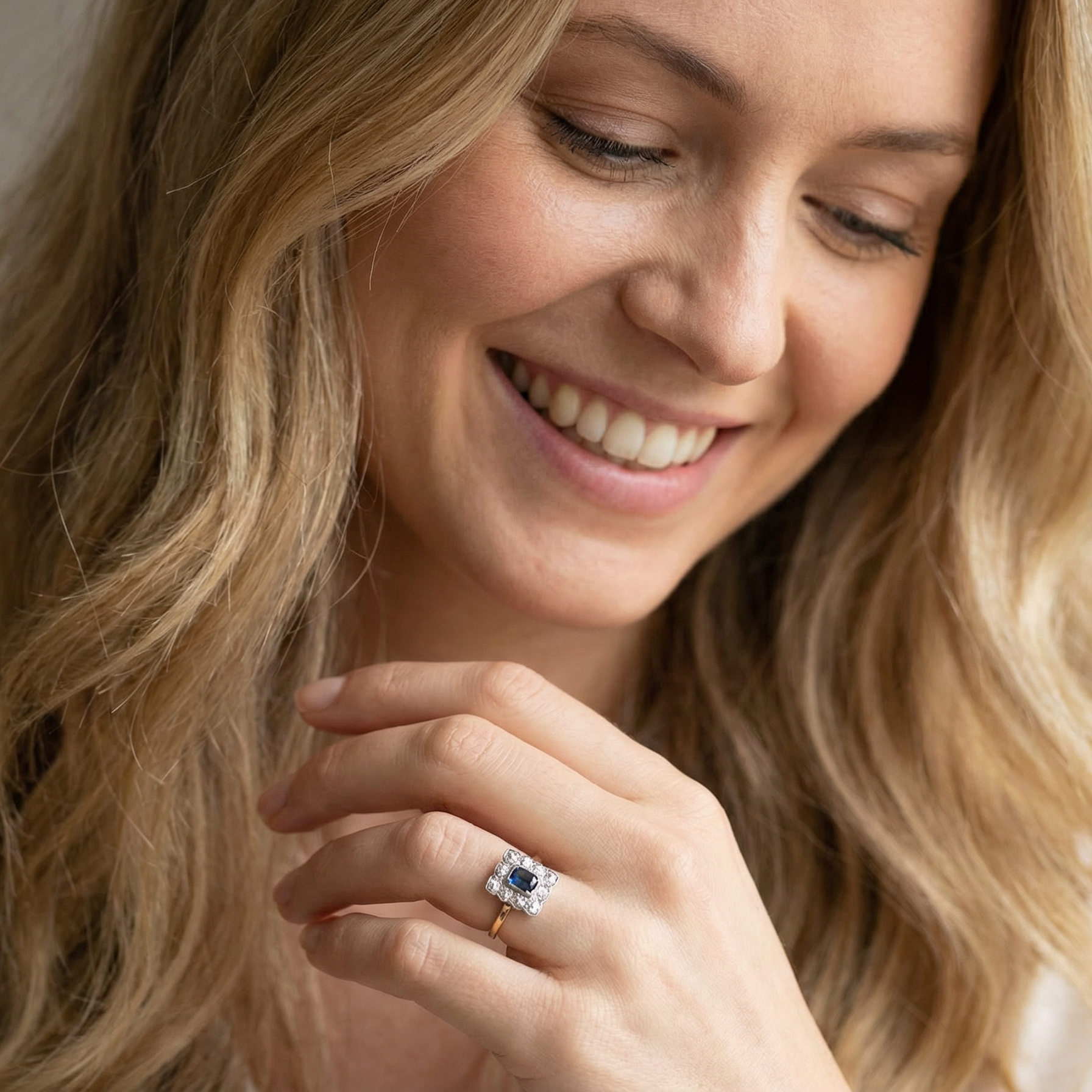 model A rectangular cluster ring that features in its centre a cushion shaped dark blue sapphire, that measures 5x3.5mm (est 0.30 carats)
