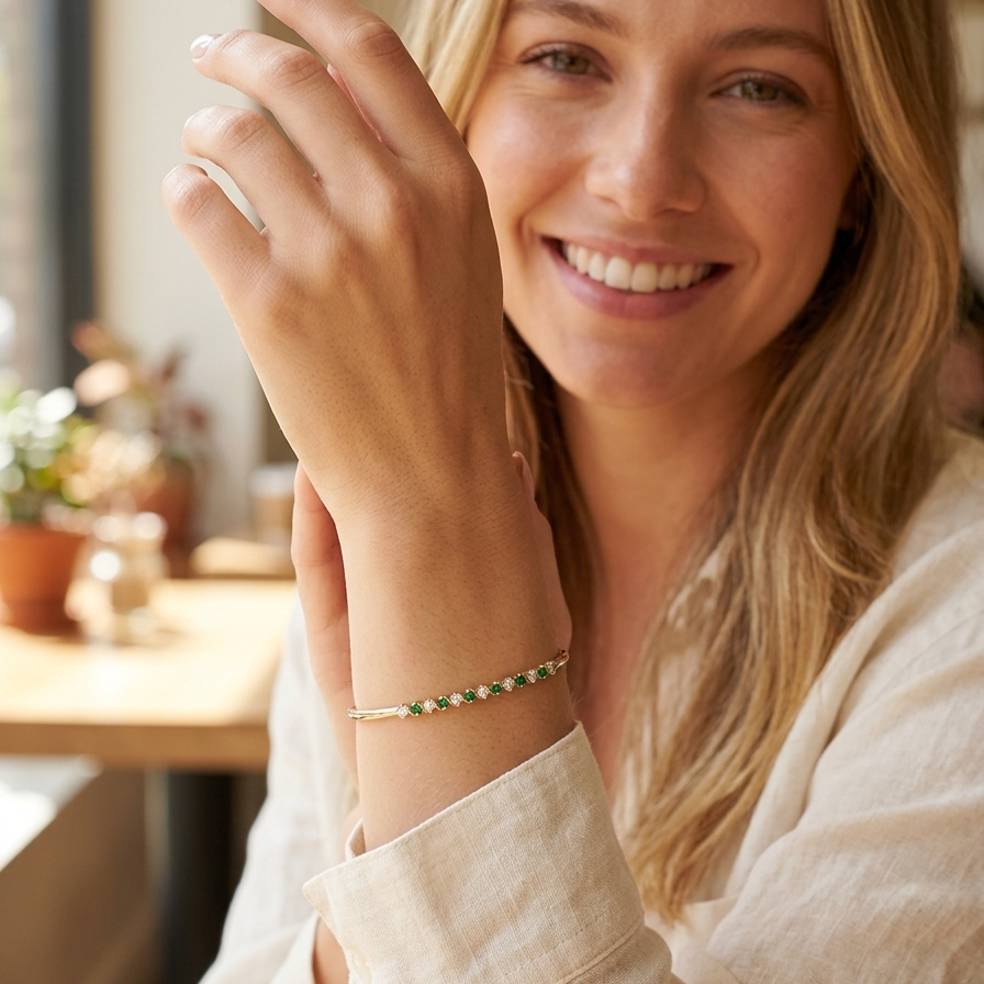 model A yellow gold bangle. Features alternate emeralds and diamonds. Six 2.7mm emeralds and seven brilliant cut white diamonds, each 2.7mm (total diamond total 0.50 carats)