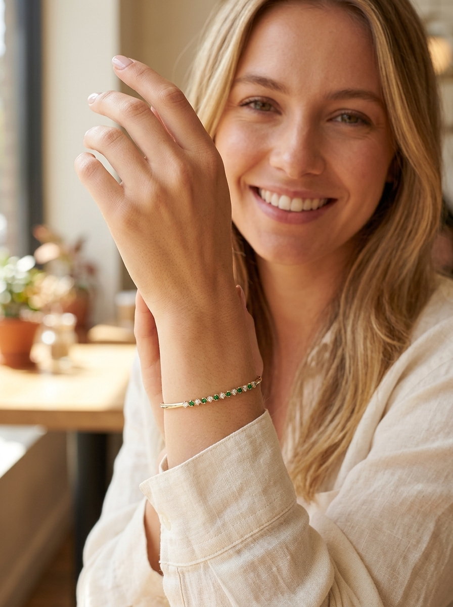 model A yellow gold bangle. Features alternate emeralds and diamonds. Six 2.7mm emeralds and seven brilliant cut white diamonds, each 2.7mm (total diamond total 0.50 carats)