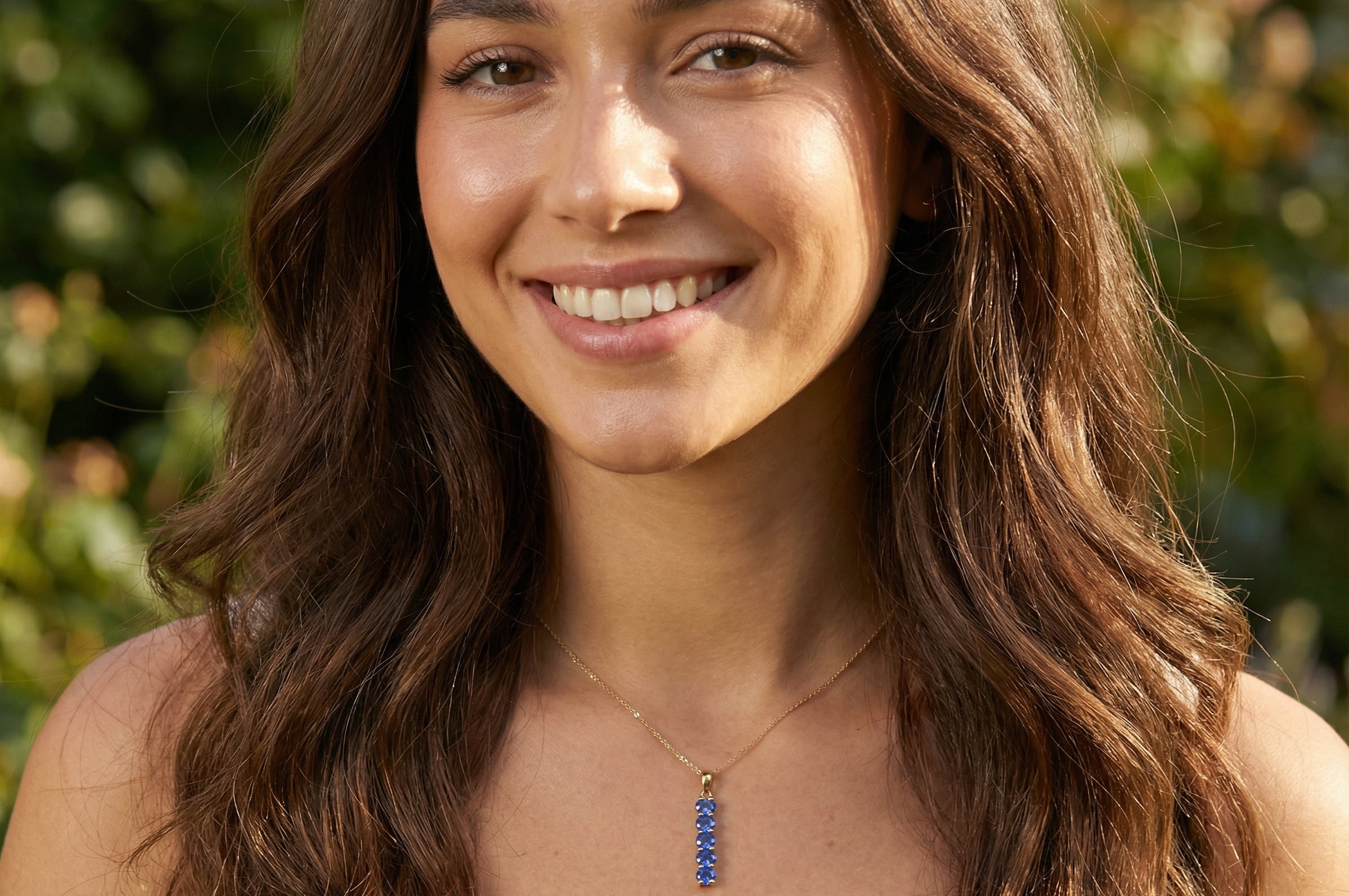 model An 18 carat yellow gold pendant. This features five oval cut mid cornflower blue sapphires, each 5x3.5mm. 