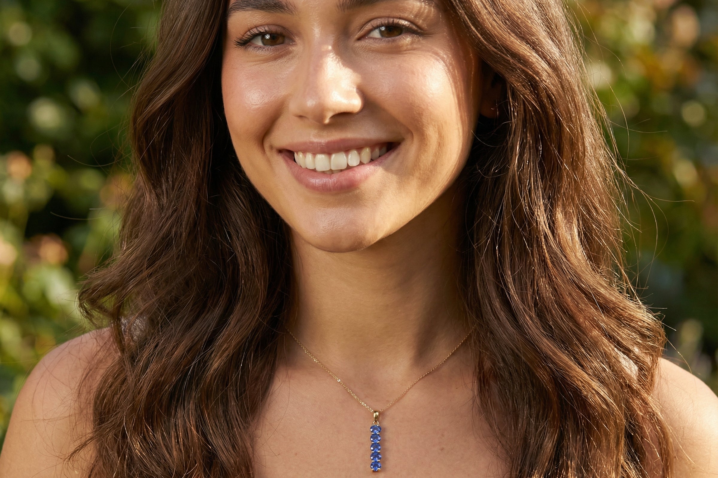 model An 18 carat yellow gold pendant. This features five oval cut mid cornflower blue sapphires, each 5x3.5mm. 