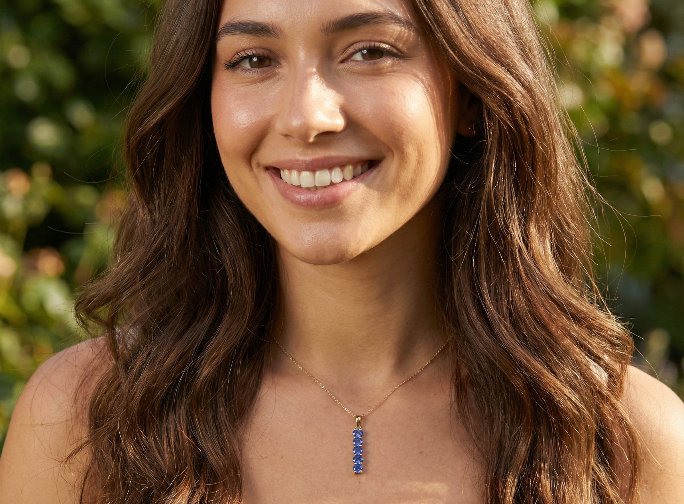model An 18 carat yellow gold pendant. This features five oval cut mid cornflower blue sapphires, each 5x3.5mm. 