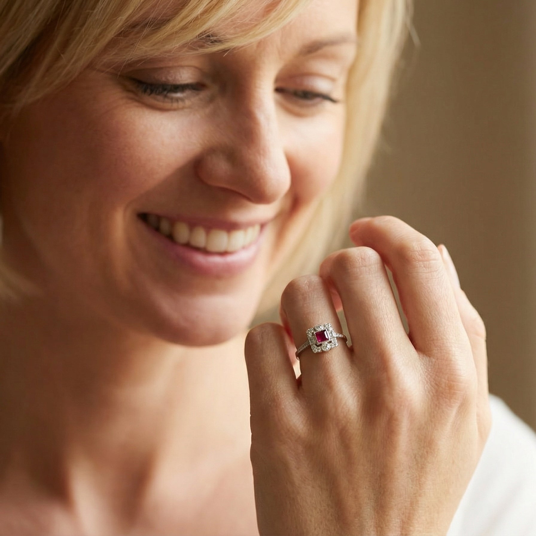 model An Art Deco style cluster ring. Set to the centre a square 5x5mm ruby, rub over setting and complimented by a surround of mixed cut white diamonds.