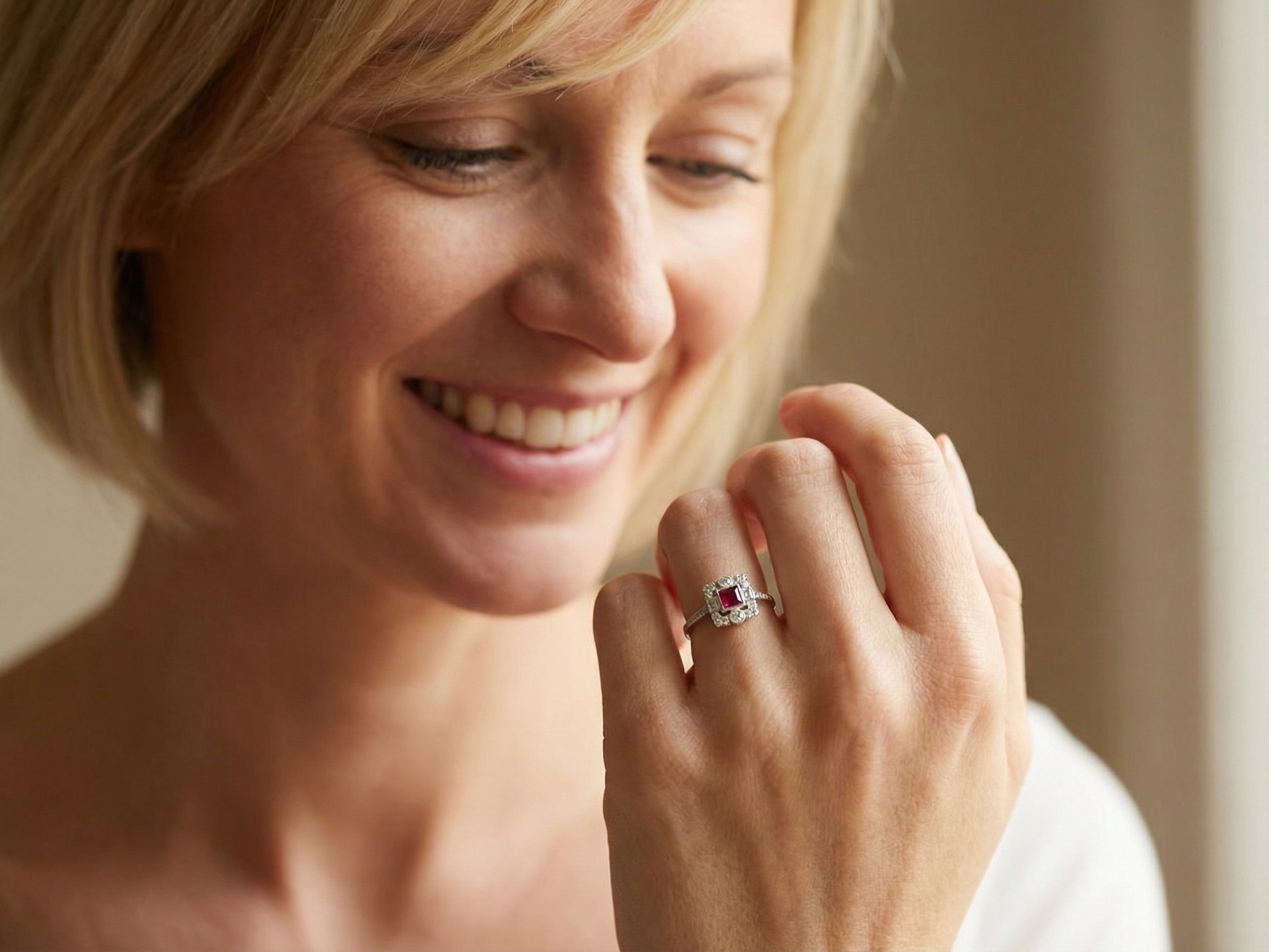 model An Art Deco style cluster ring. Set to the centre a square 5x5mm ruby, rub over setting and complimented by a surround of mixed cut white diamonds.