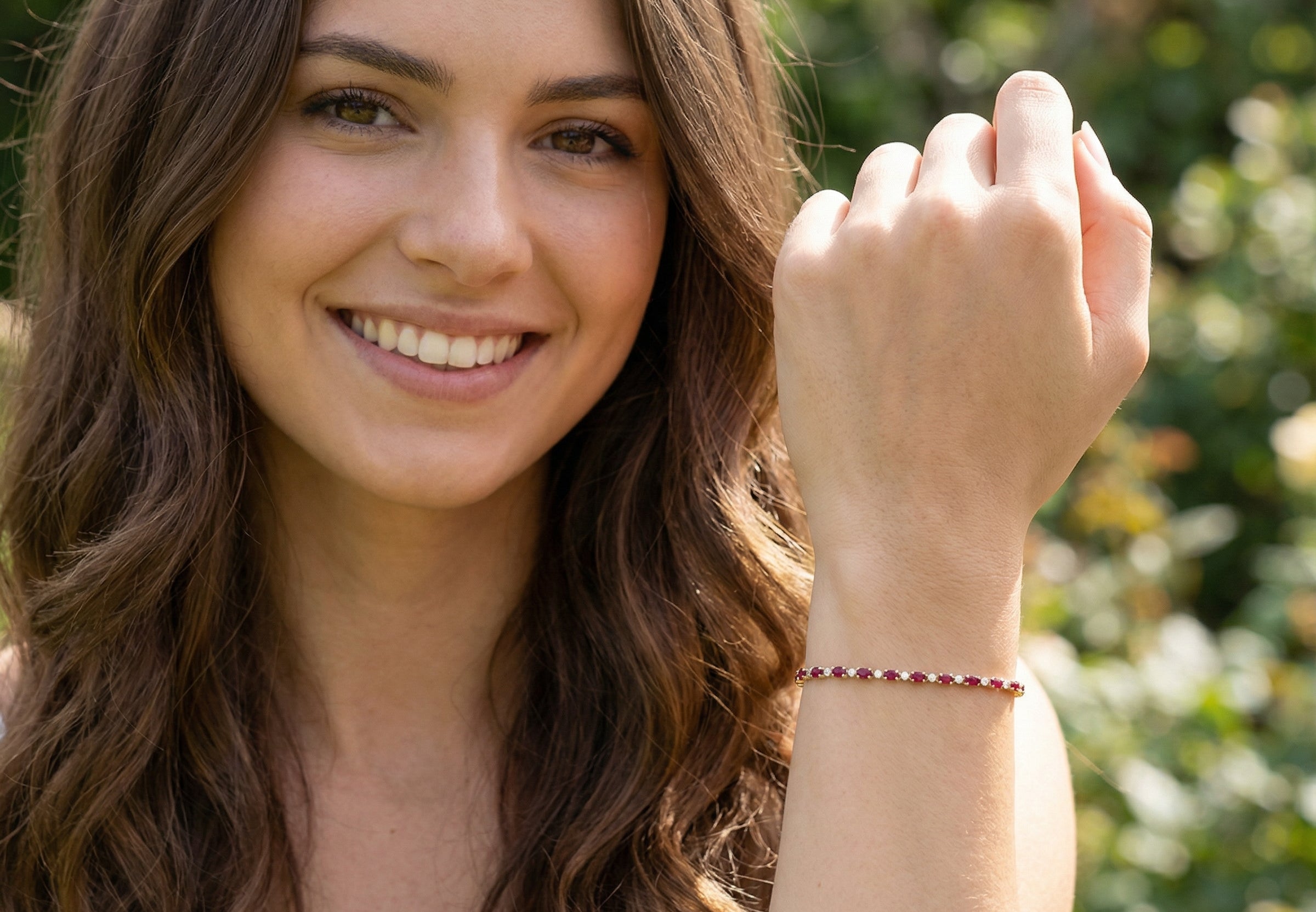 model An elegant 9 carat gold bracelet set with sixteen rich red oval-cut garnets, each measuring approximately 6 x 4mm. Between each garnet sits a delicate illusion-set diamond in white gold, creating the appearance of larger stones while adding subtle sparkle. The total diamond weight is estimated at 0.15 carats.