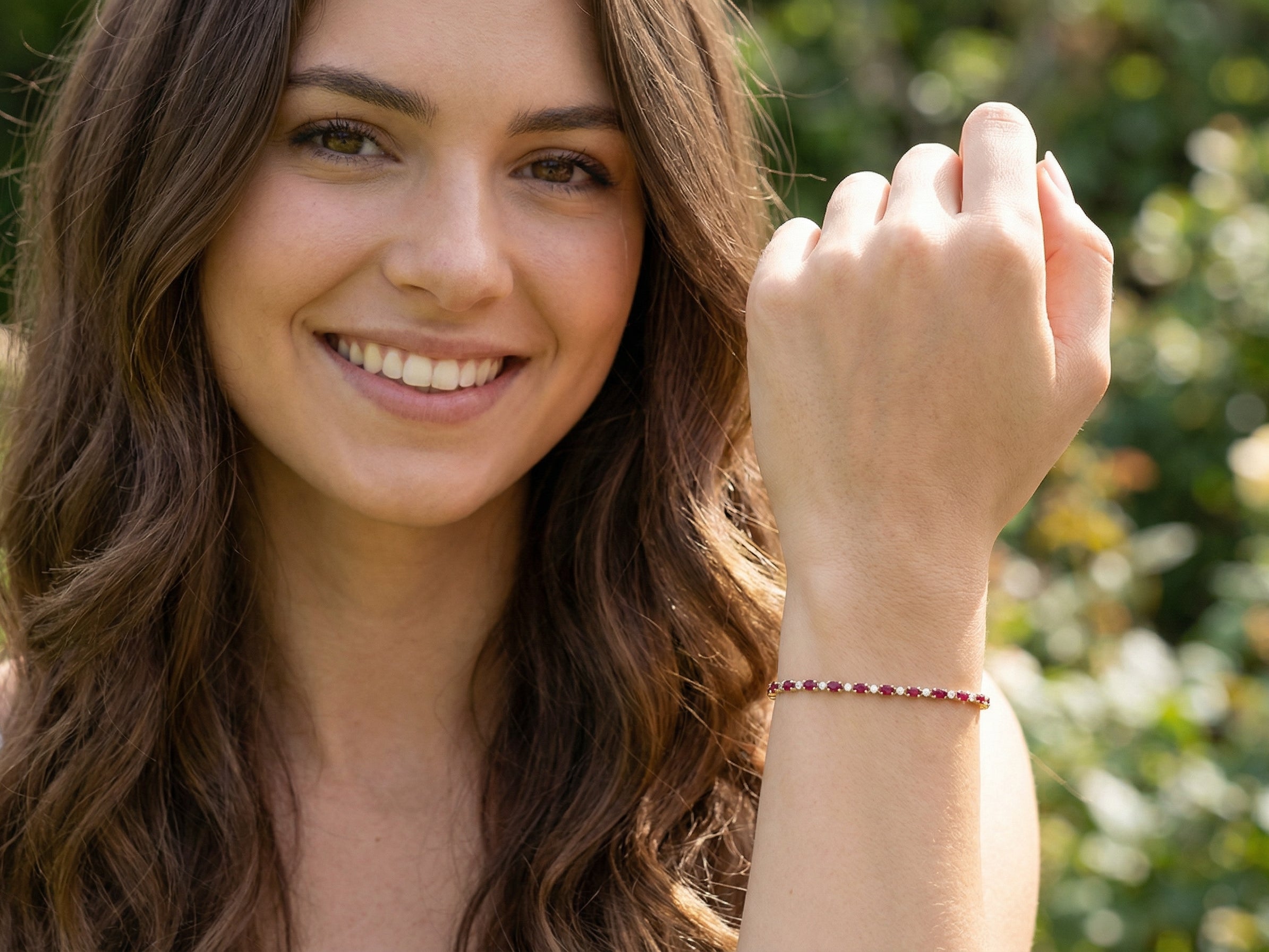 model An elegant 9 carat gold bracelet set with sixteen rich red oval-cut garnets, each measuring approximately 6 x 4mm. Between each garnet sits a delicate illusion-set diamond in white gold, creating the appearance of larger stones while adding subtle sparkle. The total diamond weight is estimated at 0.15 carats.
