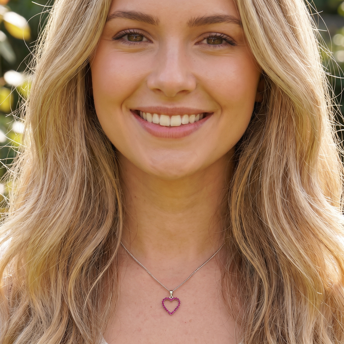 model An elegant and beautifully crafted open heart pendant, set with a delightful arrangement of delicate pink sapphires, creating a charming and feminine design.