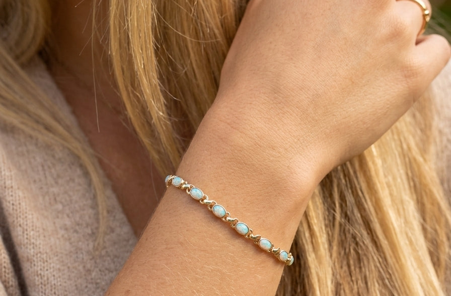 model An elegant line bracelet set with fourteen oval opals, each measuring approximately 5 x 3 mm, displaying a pleasing and lively play of colour.
