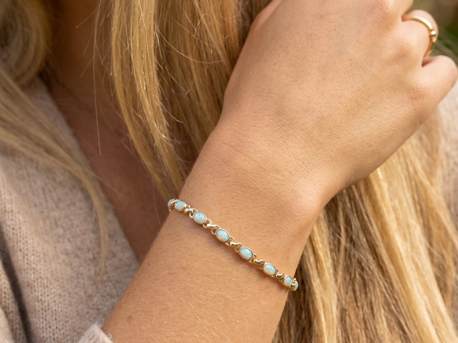model An elegant line bracelet set with fourteen oval opals, each measuring approximately 5 x 3 mm, displaying a pleasing and lively play of colour.