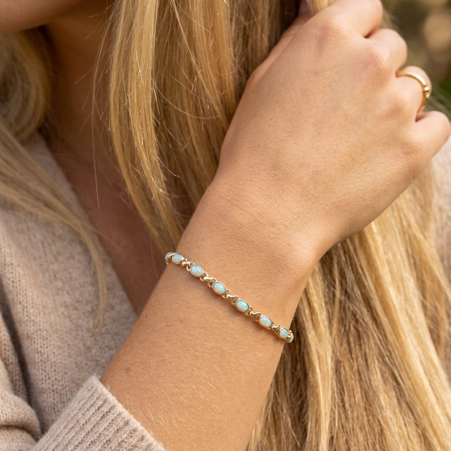 model An elegant line bracelet set with fourteen oval opals, each measuring approximately 5 x 3 mm, displaying a pleasing and lively play of colour.