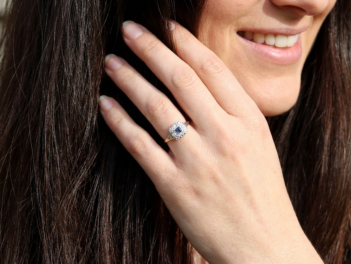 model antique cluster ring. Features a small square sapphire