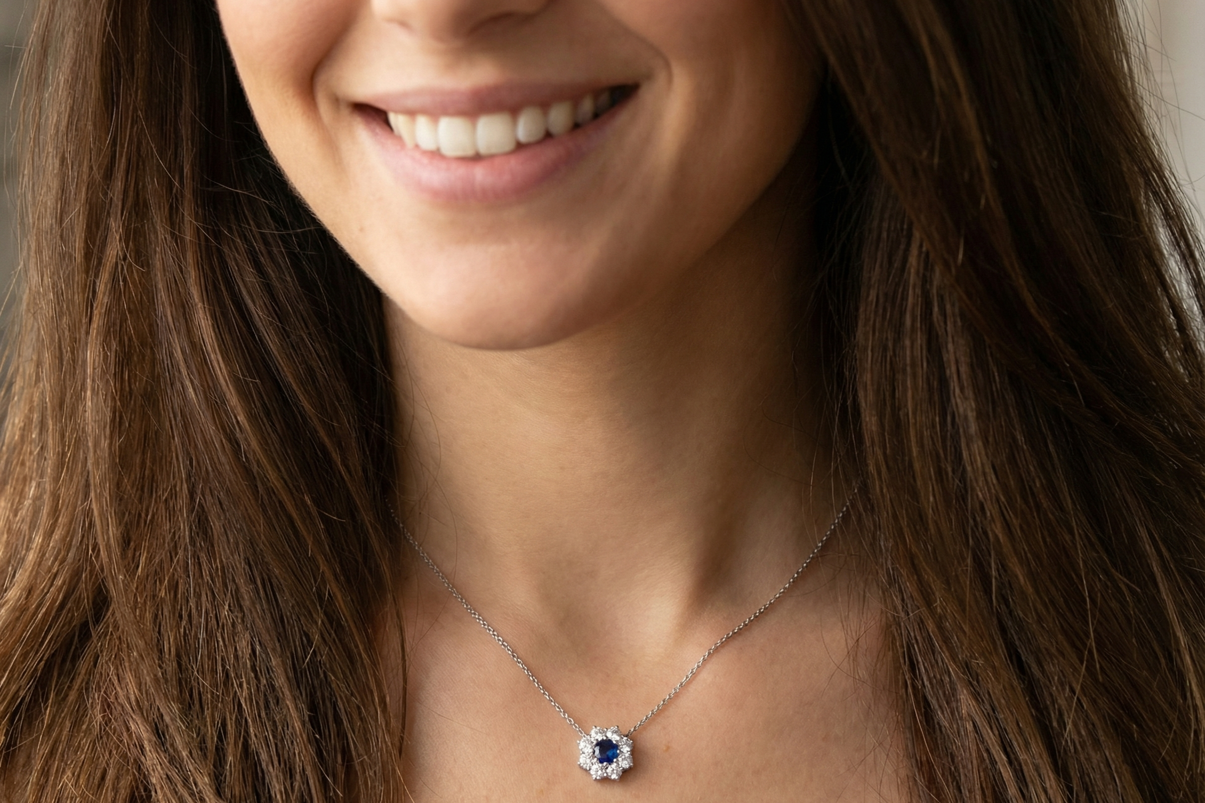 model pendant with a vibrant blue sapphire at its centre.