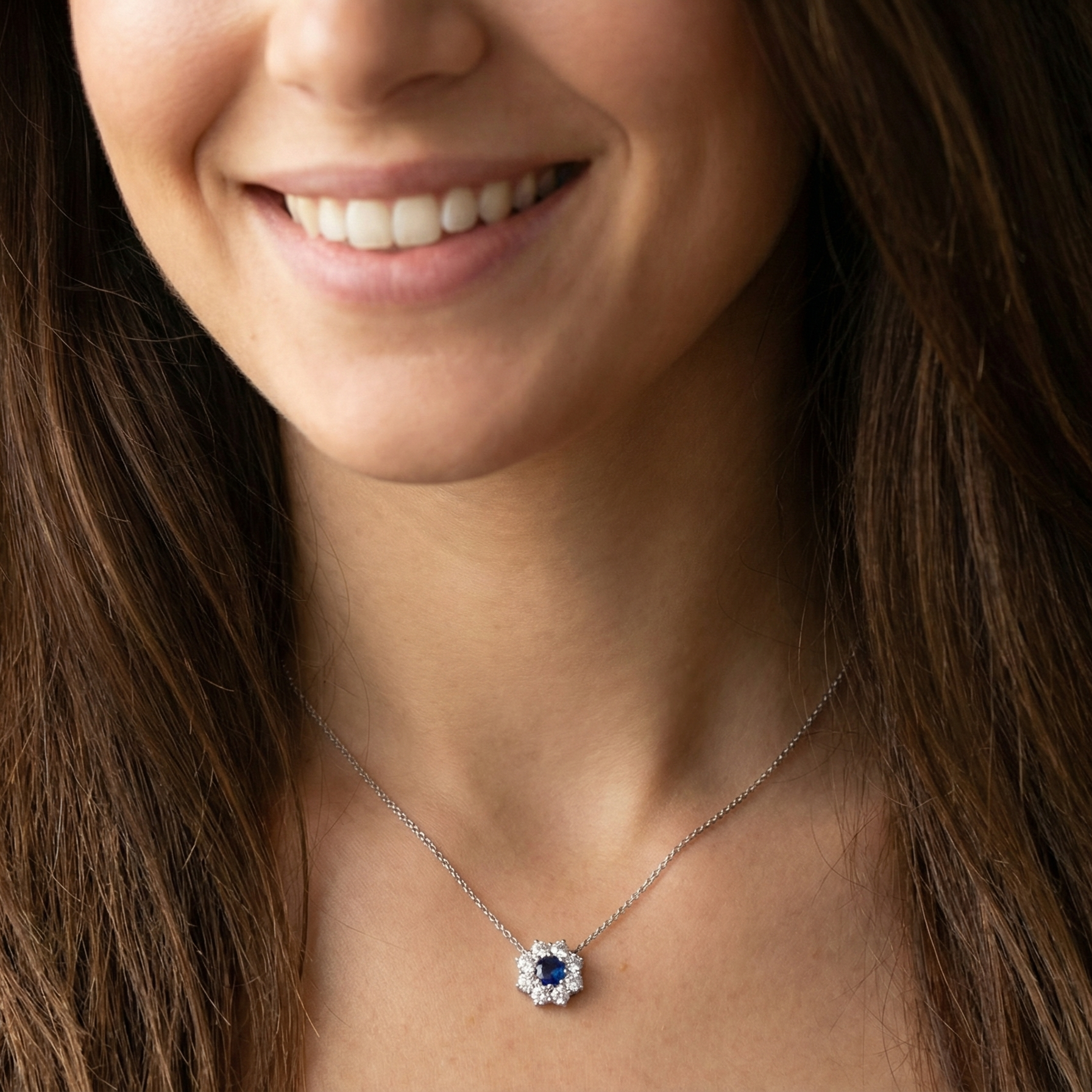 model pendant with a vibrant blue sapphire at its centre.