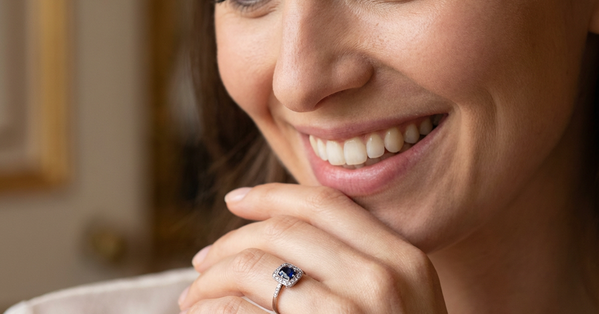 model beautiful original Art Deco cluster ring featuring a rich, dark blue oval-cut sapphire