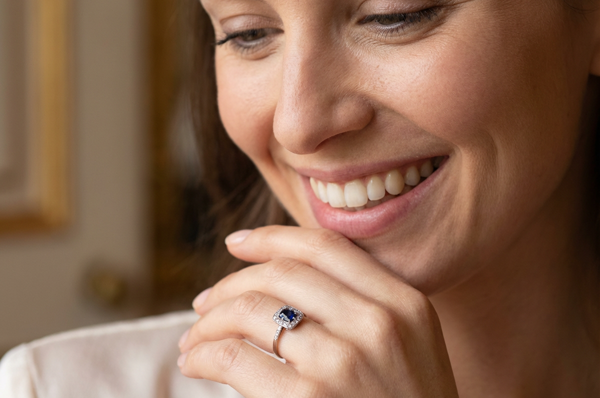 model beautiful original Art Deco cluster ring featuring a rich, dark blue oval-cut sapphire