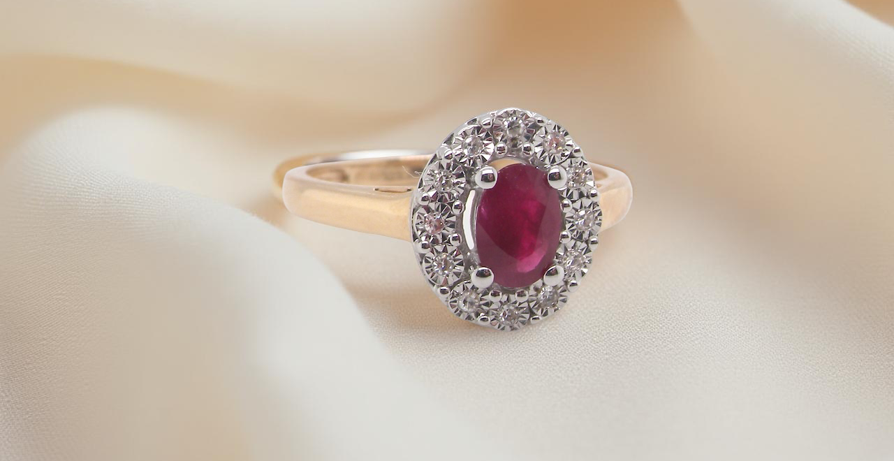 oval ruby measuring 6x4mm (approx. 0.44 carats) in a raspberry red hue. The centre stone is accented by a twelve white diamonds
