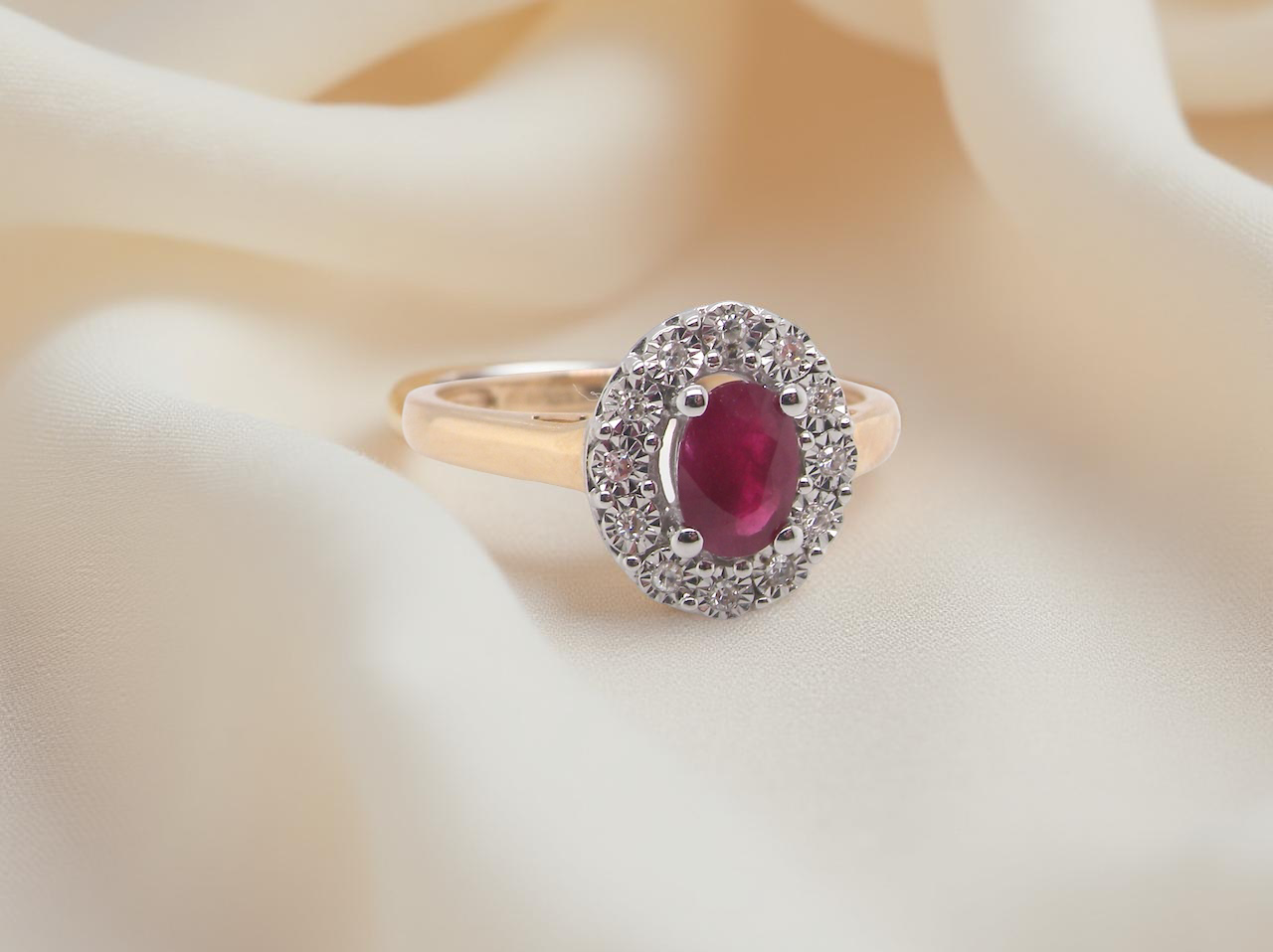 oval ruby measuring 6x4mm (approx. 0.44 carats) in a raspberry red hue. The centre stone is accented by a twelve white diamonds