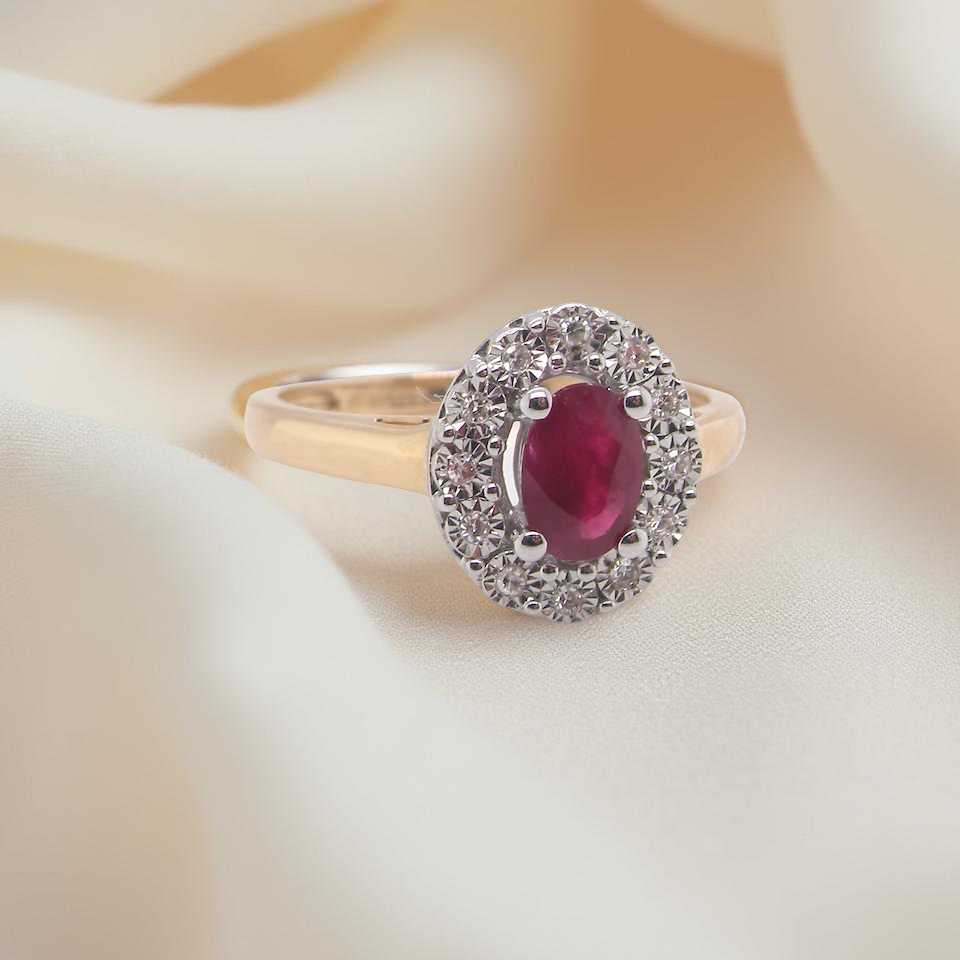 oval ruby measuring 6x4mm (approx. 0.44 carats) in a raspberry red hue. The centre stone is accented by a twelve white diamonds