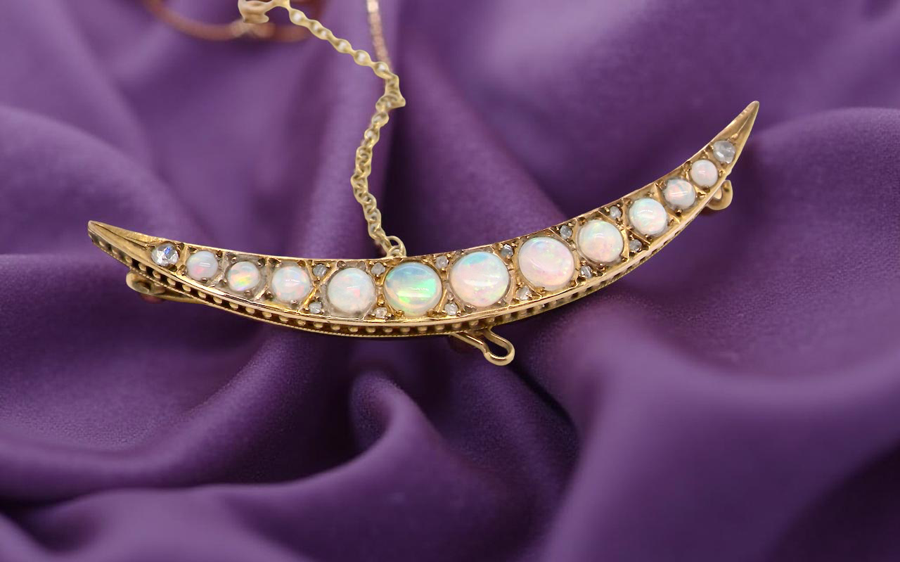 An Edwardian opal crescent shaped brooch