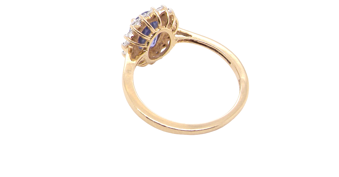 rear A 14 carat gold cluster ring. Features to the centre an oval cut cornflower blue sapphire, 8x6mm (est 1.25 carats), four claw setting.
