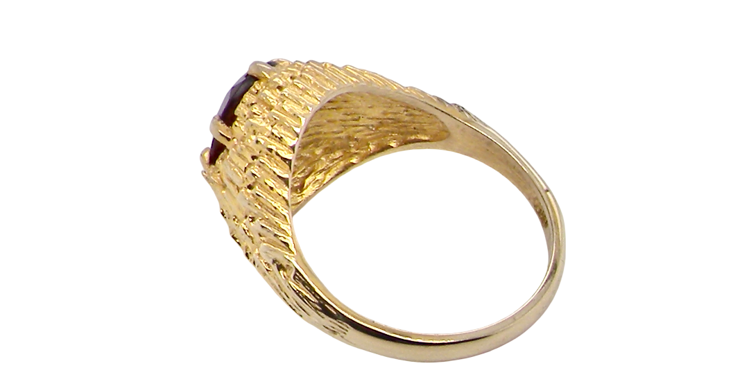rear A 1970s dress ring set with an oval garnet stone. This measures 10x8mm and claw set.