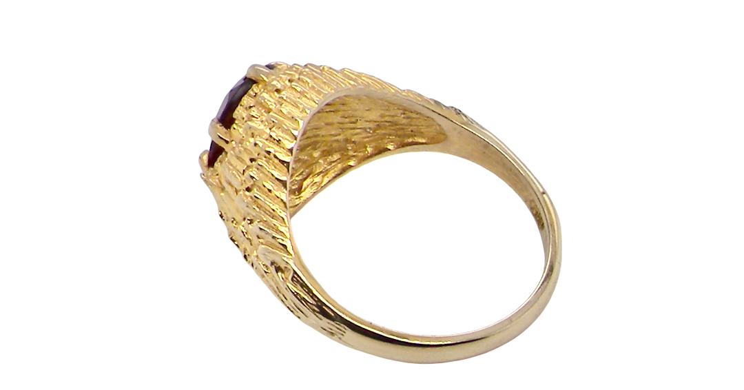 rear A 1970s dress ring set with an oval garnet stone. This measures 10x8mm and claw set.