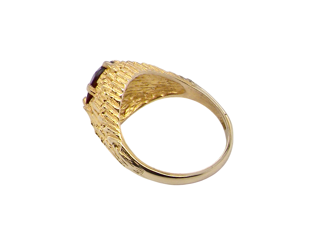 rear A 1970s dress ring set with an oval garnet stone. This measures 10x8mm and claw set.