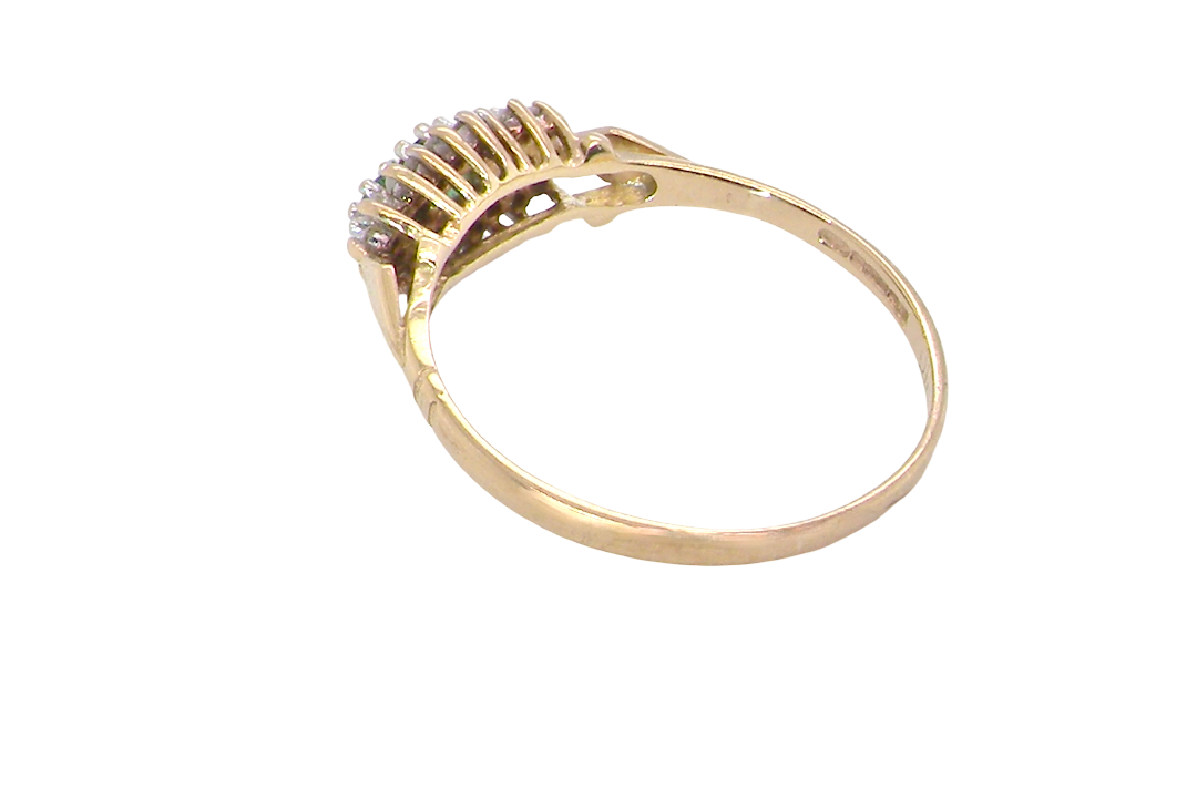 rear A 9 carat gold cluster ring. Set to the centre three round emeralds, centre 3.2mm, each side a 2.6mm stone.