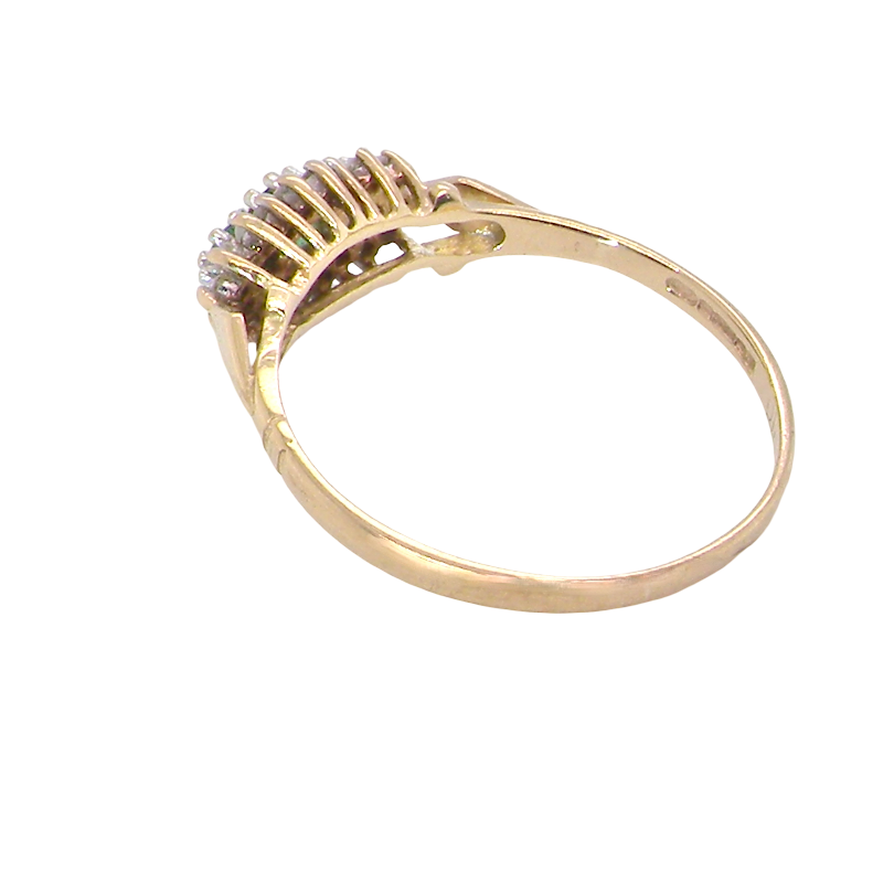 rear A 9 carat gold cluster ring. Set to the centre three round emeralds, centre 3.2mm, each side a 2.6mm stone.