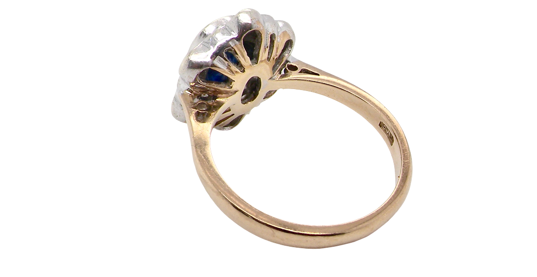 rear A 9 carat gold cluster ring that features an inky black blue oval cut sapphire. This measures 8x6mm in a safe rim style setting