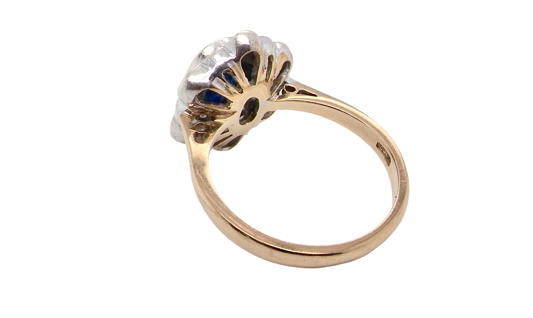 rear A 9 carat gold cluster ring that features an inky black blue oval cut sapphire. This measures 8x6mm in a safe rim style setting