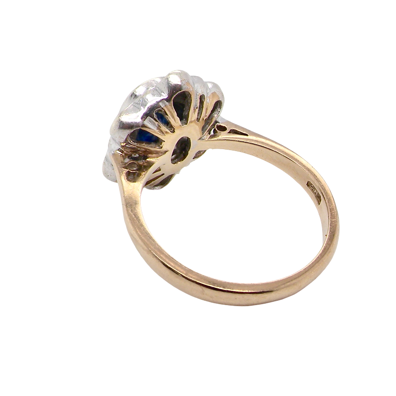 rear A 9 carat gold cluster ring that features an inky black blue oval cut sapphire. This measures 8x6mm in a safe rim style setting