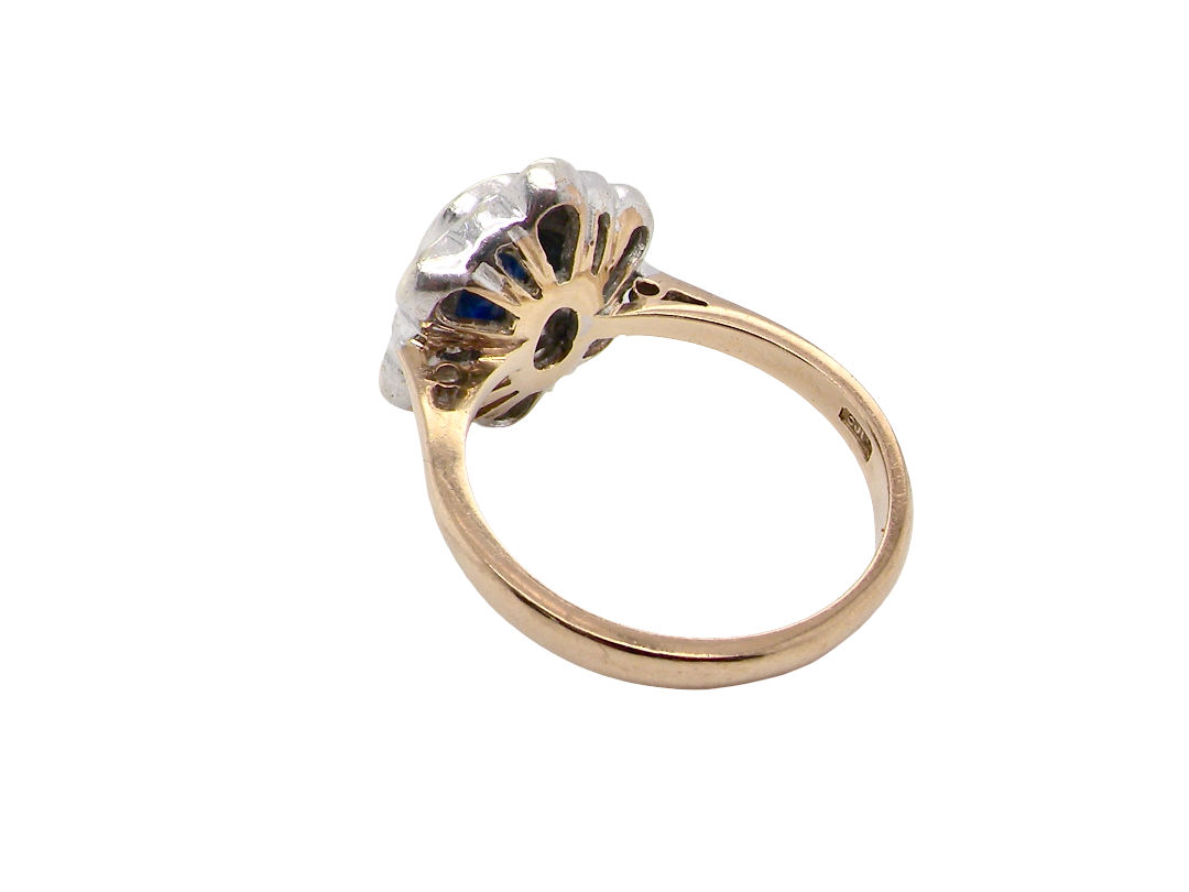 rear A 9 carat gold cluster ring that features an inky black blue oval cut sapphire. This measures 8x6mm in a safe rim style setting