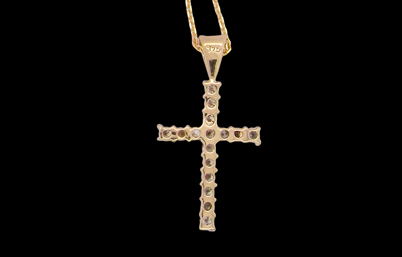 rear A 9 carat gold cross pendant. Set with fifteen small brilliant cut white diamonds.
Each 1.6mm, total carat weight estimated at 0.30 carats. Colour i-k, clarity Si. Overall size 18x12.5mm. Attached to an 18' neck chain.