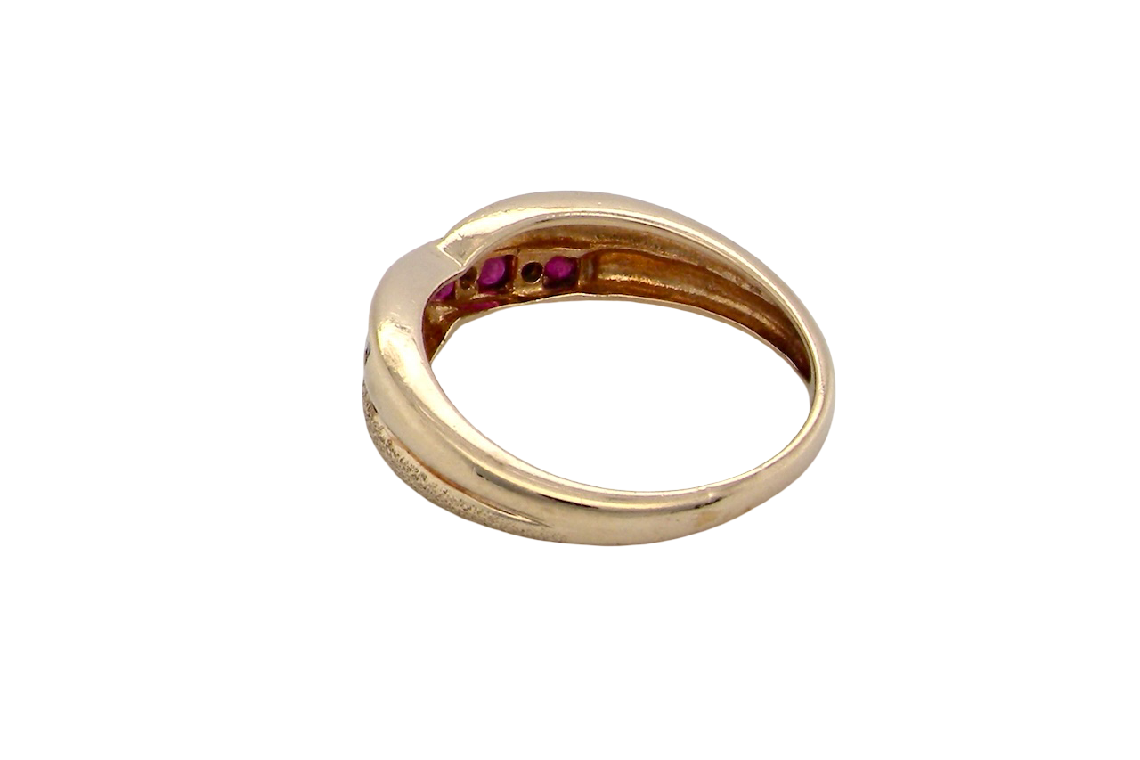 rear A 9 carat gold half hoop eternity ring. Set with five calibre cut rubies, from 1.7 to 2mm, and between small 1mm white diamonds.
