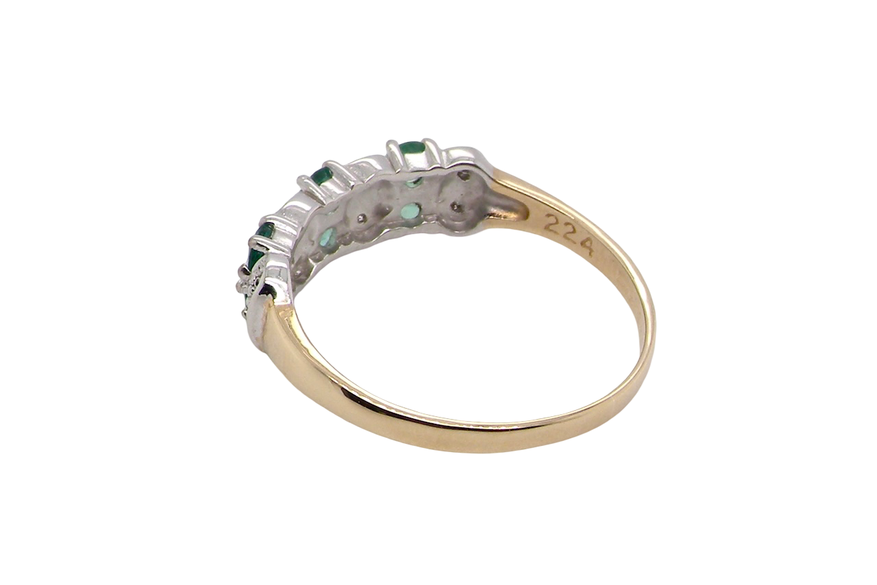 rear A 9 carat gold half hoop ring. Set with six round emeralds 3mm each,(total 0.35 carats est) and interspaced with vertical white gold sections each set with 1mm diamonds.(0.05 carats est)