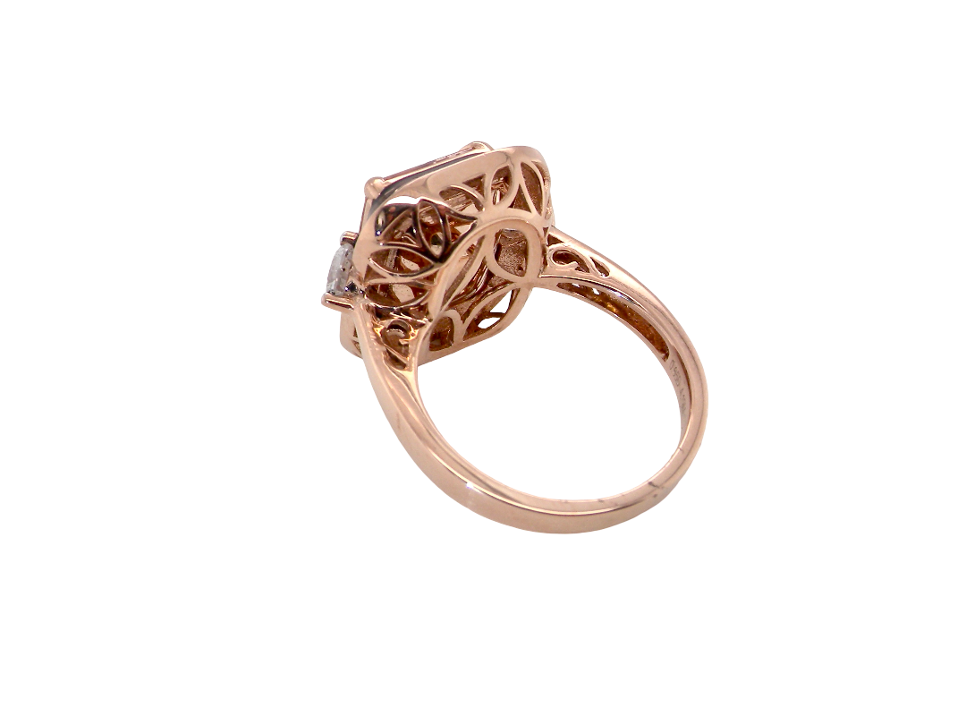 A rose gold filigree ring with a square-cut clear gemstone, shown from a side angle on a plain white background.