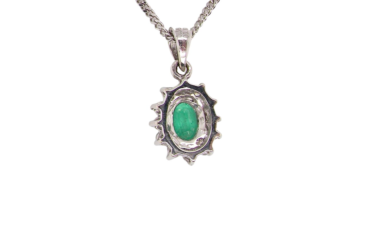 rear A beautiful traditional cluster pendant featuring a vibrant oval-cut emerald