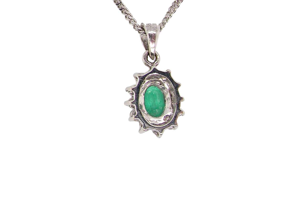 rear A beautiful traditional cluster pendant featuring a vibrant oval-cut emerald