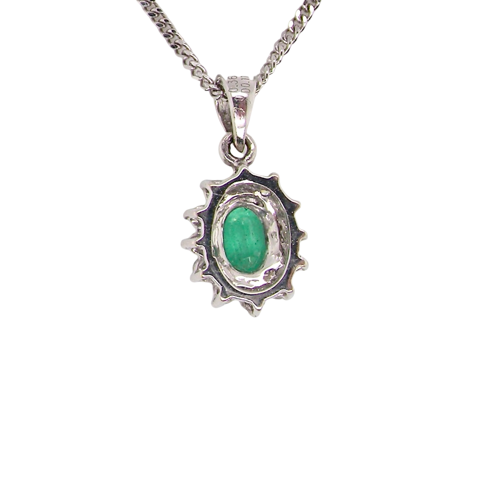 rear A beautiful traditional cluster pendant featuring a vibrant oval-cut emerald