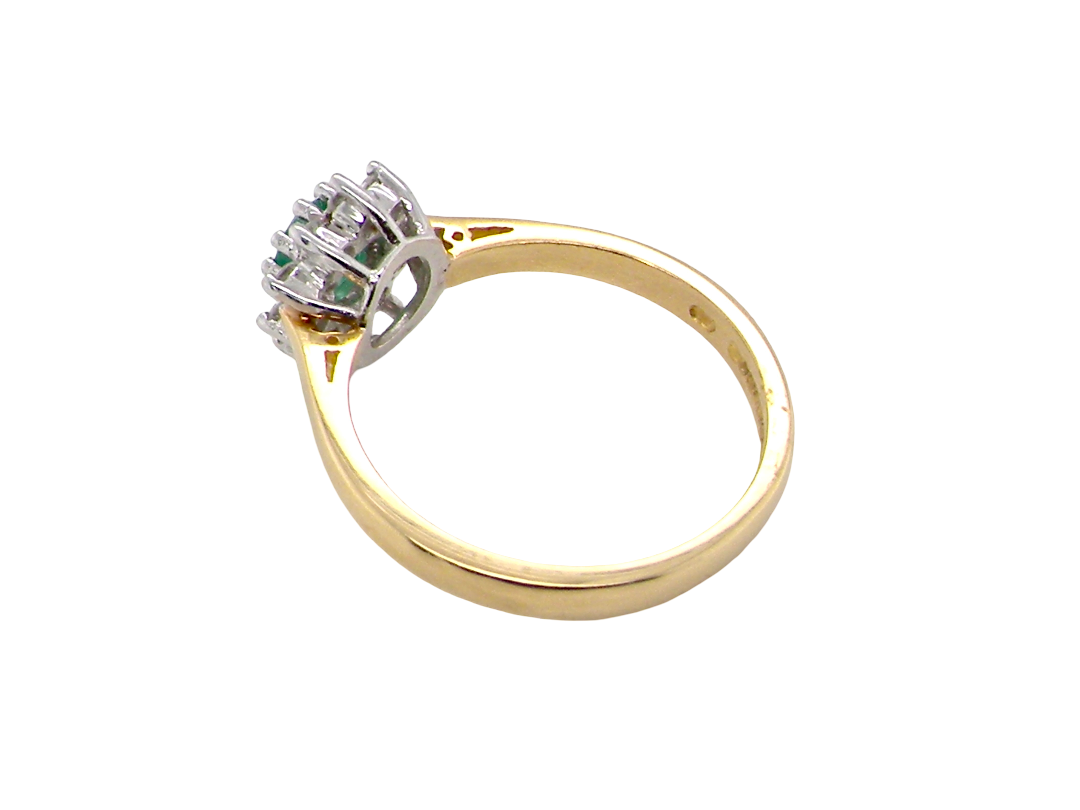 A classic cluster ring. Features to the centre a round emerald, comlimented by an outer halo of brilliant cut white diamonds